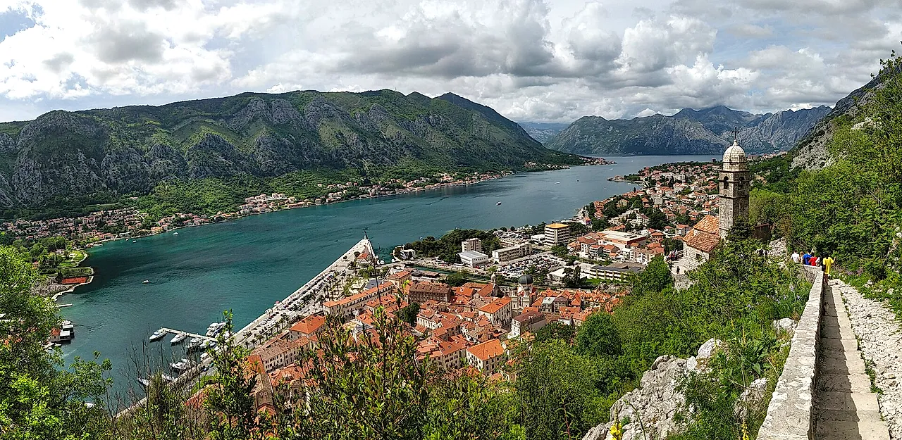 Panorama of the Bay of Kotor and the old town from the path on the walls, with clouds over the mountains